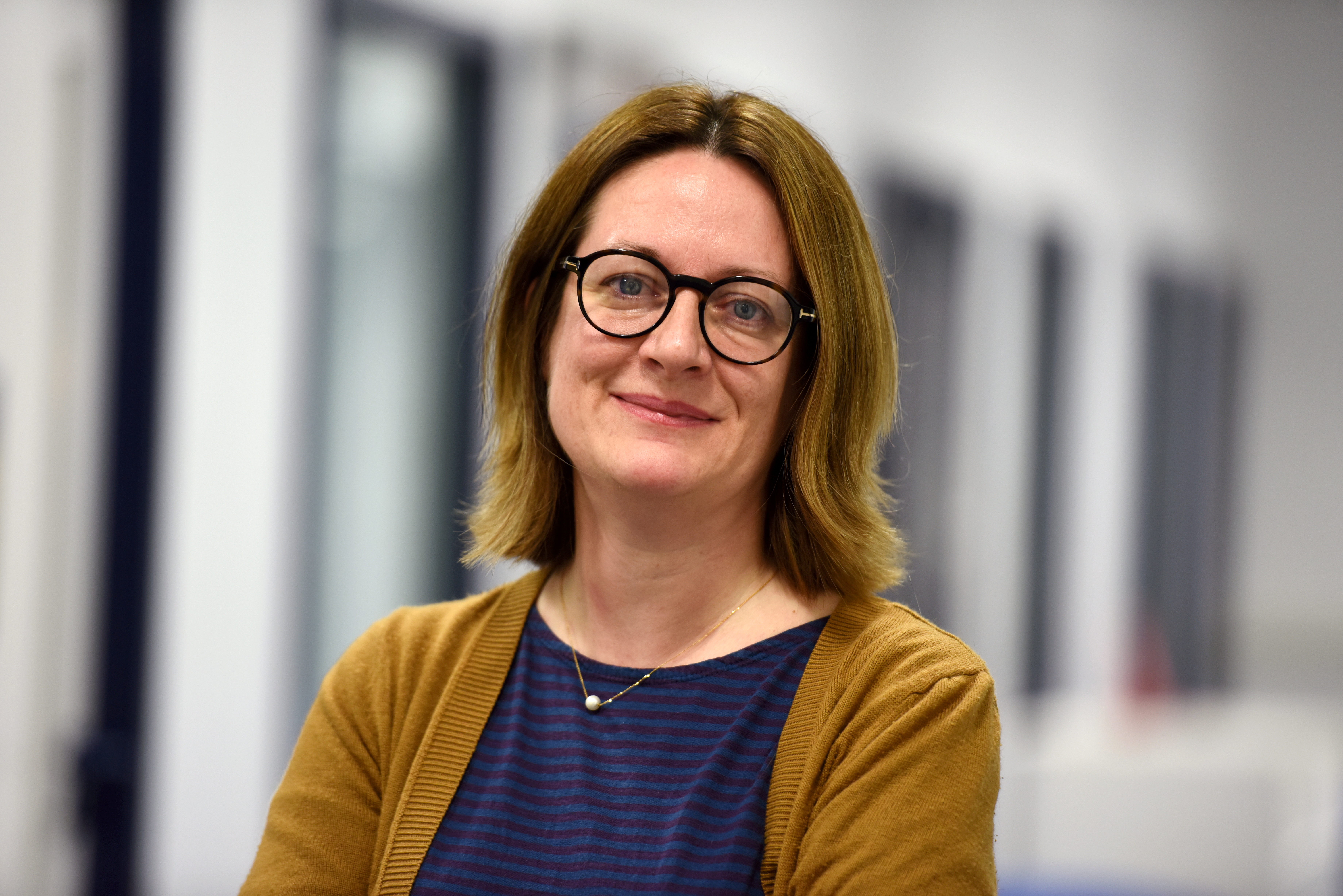 colour headshot photograph of lady wearing glasses