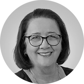 head shot of a person in glasses smiling