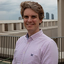 man smiling in a pink shirt