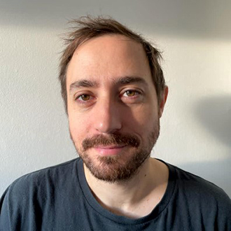 man with beard wearing a black T-shirt smiling